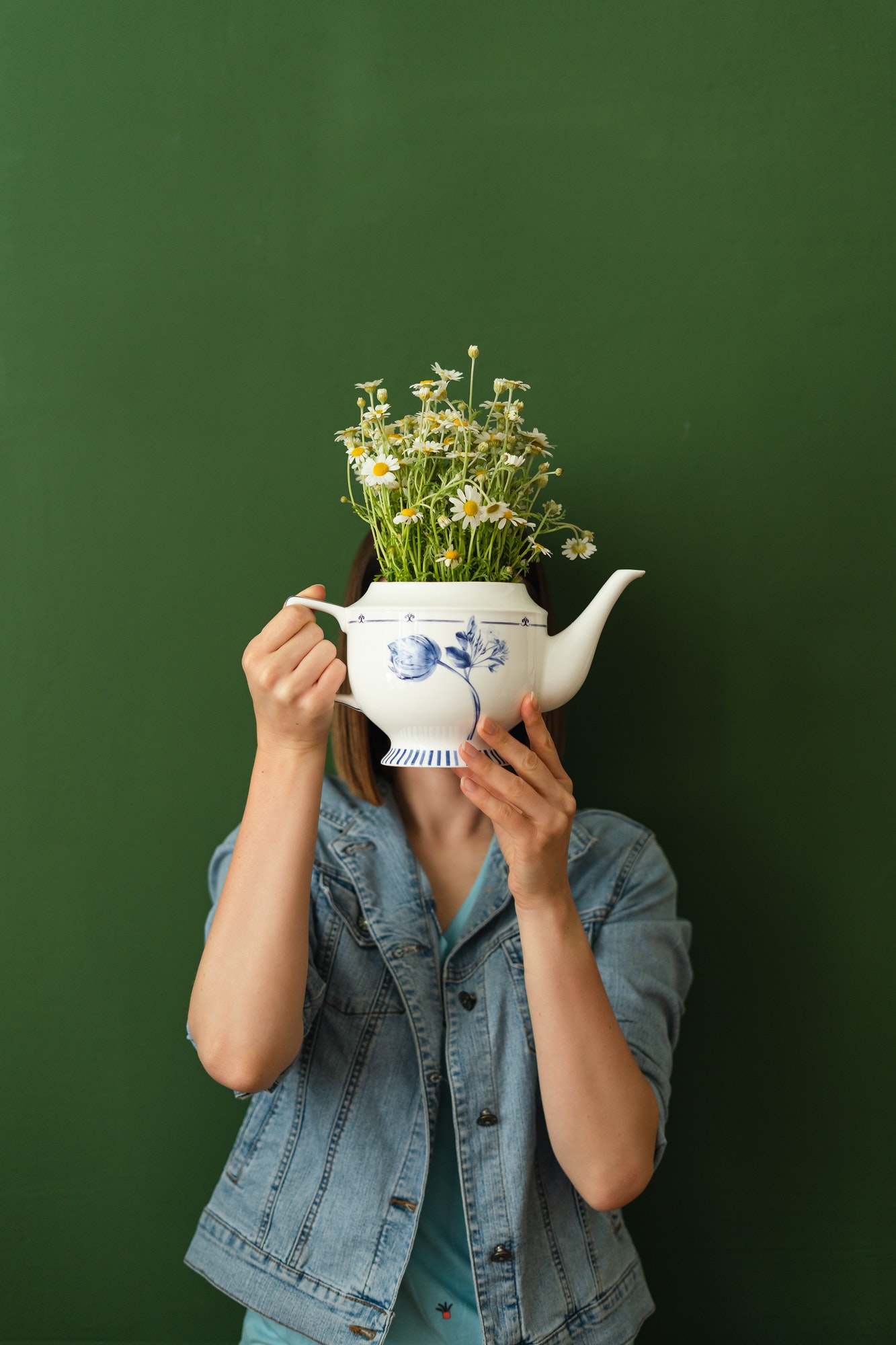 Young Woman Hold Flowers Teapot hiding head